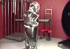 Blonde girl in black latex catsuit full encased in inflatable rubber and full body plastic suit